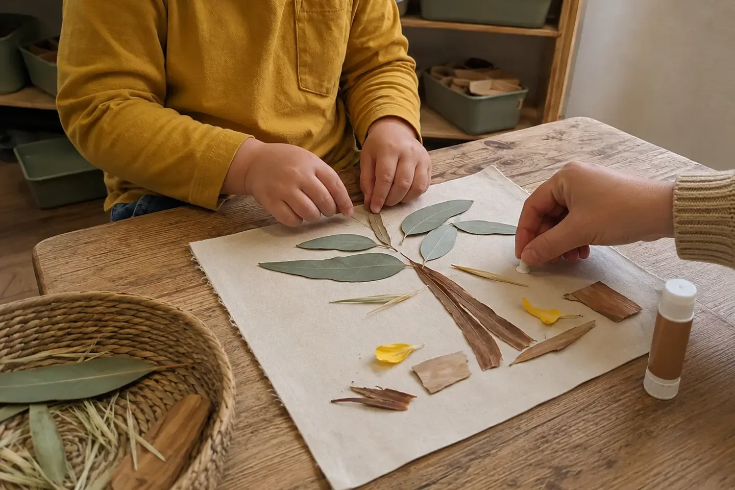 Preschool child making a nature collage with leaves, petals and other safe natural materials